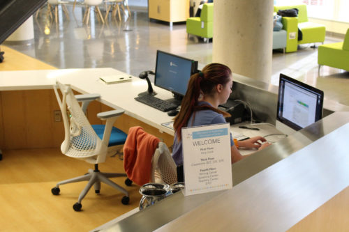 Hotel receptionist typing on a computer